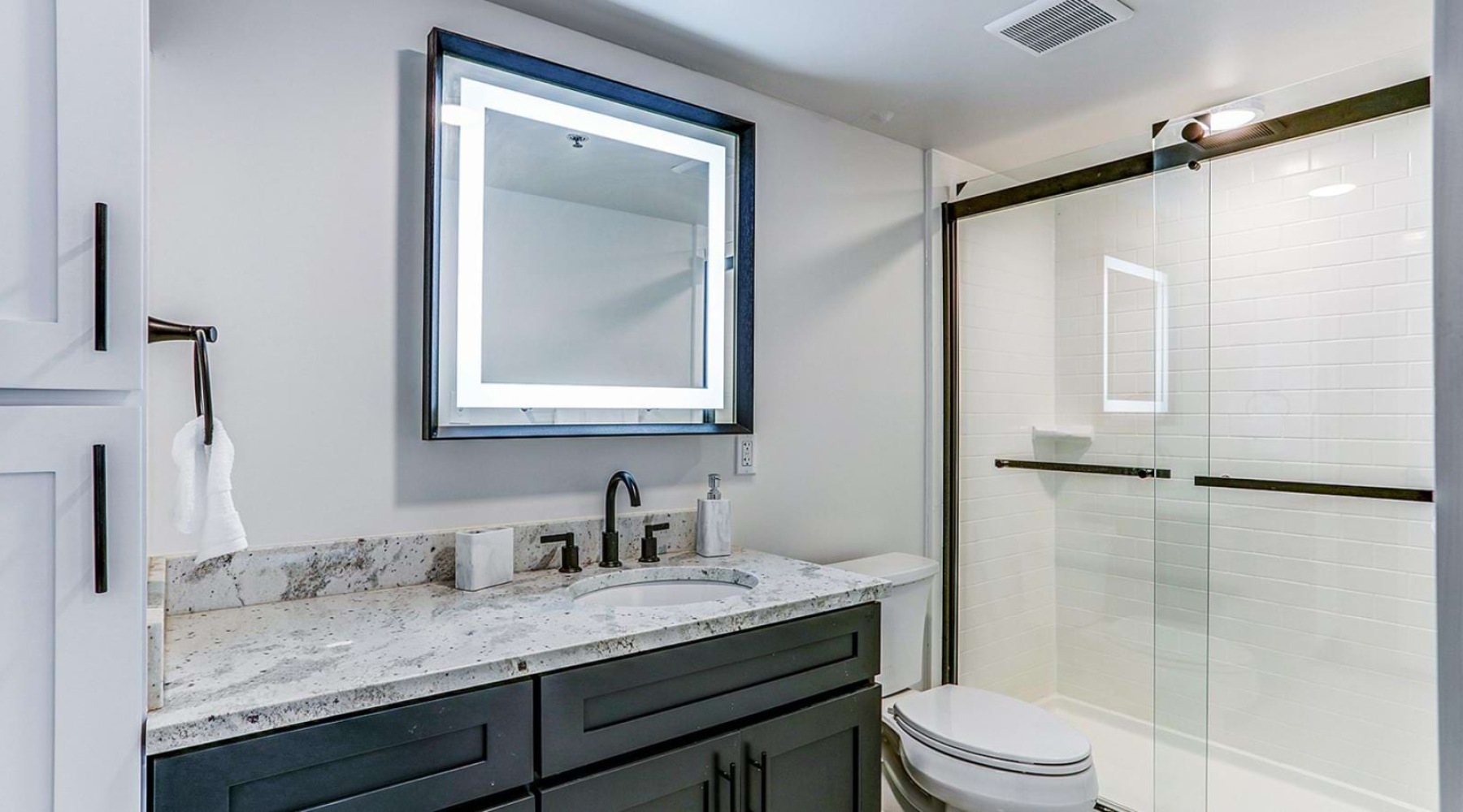 a bathroom with a marble countertop inside a Dalton Station studio apartment in Dalton, Georgia.