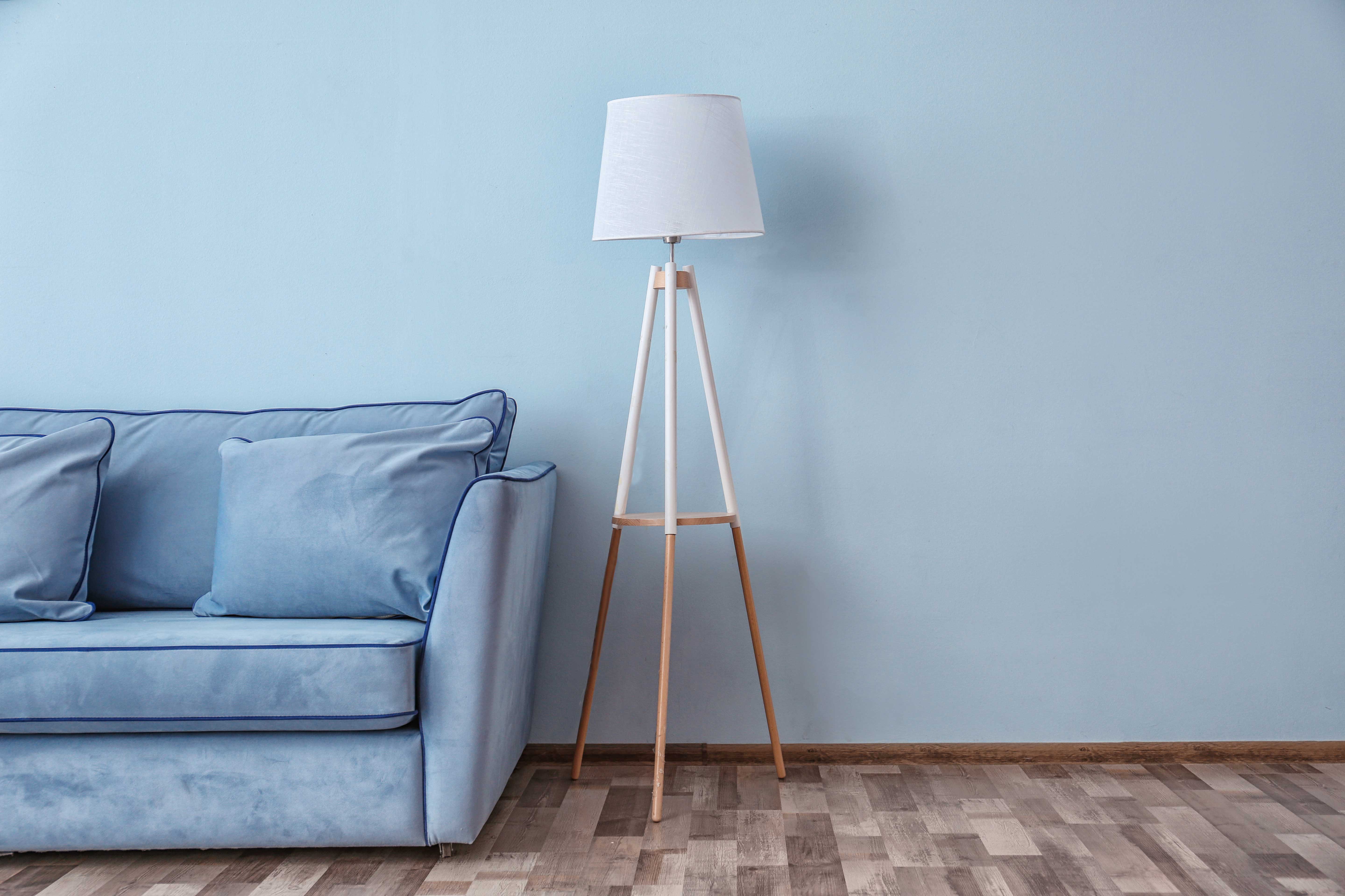 denim-couch-in-living-room-with-baby-blue-walls-and-medium-brown-flooring